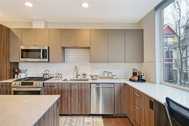 a kitchen with a sink a stove a microwave and wooden cabinets