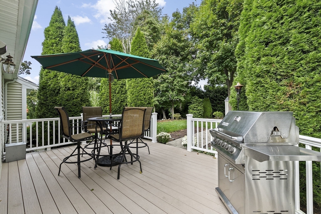 166 Phipps Street Quincy, MA 02169 - Photo 17 of 21 a view of a roof deck with table and chairs under an umbrella with wooden floor