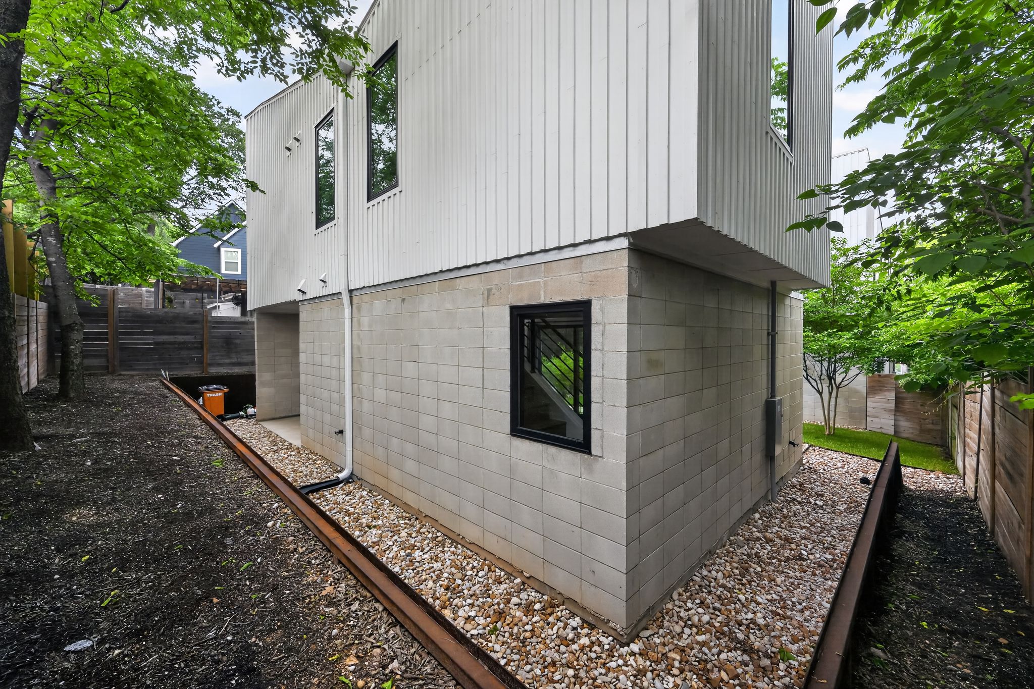 1206 Luna Street, Unit 2 Austin, TX 78721 - Photo 30 of 30 The property features a contemporary architectural style with a white vertical panel exterior and a block foundation