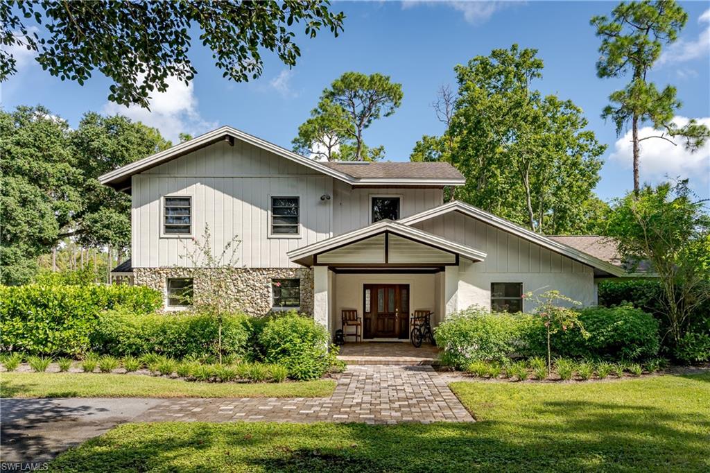 3301 31st Avenue Southwest Naples, FL 34117 - Photo 2 of 22 a front view of a house with a yard