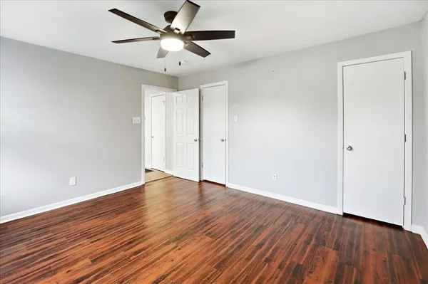 an empty room with wooden floor and windows