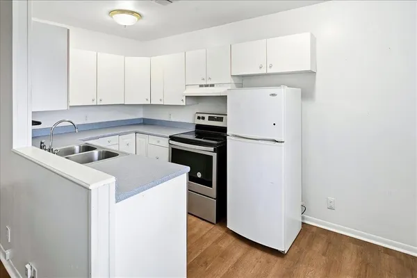 a kitchen with white cabinets and white appliances