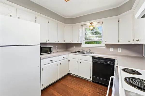 a kitchen with granite countertop white cabinets and white appliances