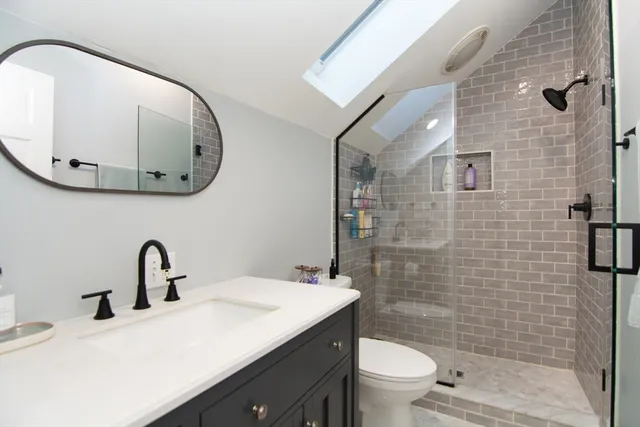 a bathroom with a sink a toilet and mirror