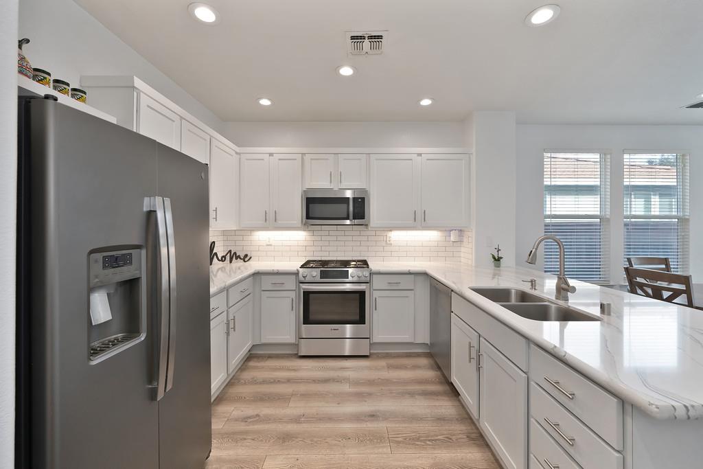 250 Pelican Bay Circle Sacramento, CA 95835 - Photo 15 of 71 a kitchen with stainless steel appliances granite countertop refrigerator a sink a stove top oven and a dishwasher next to a window