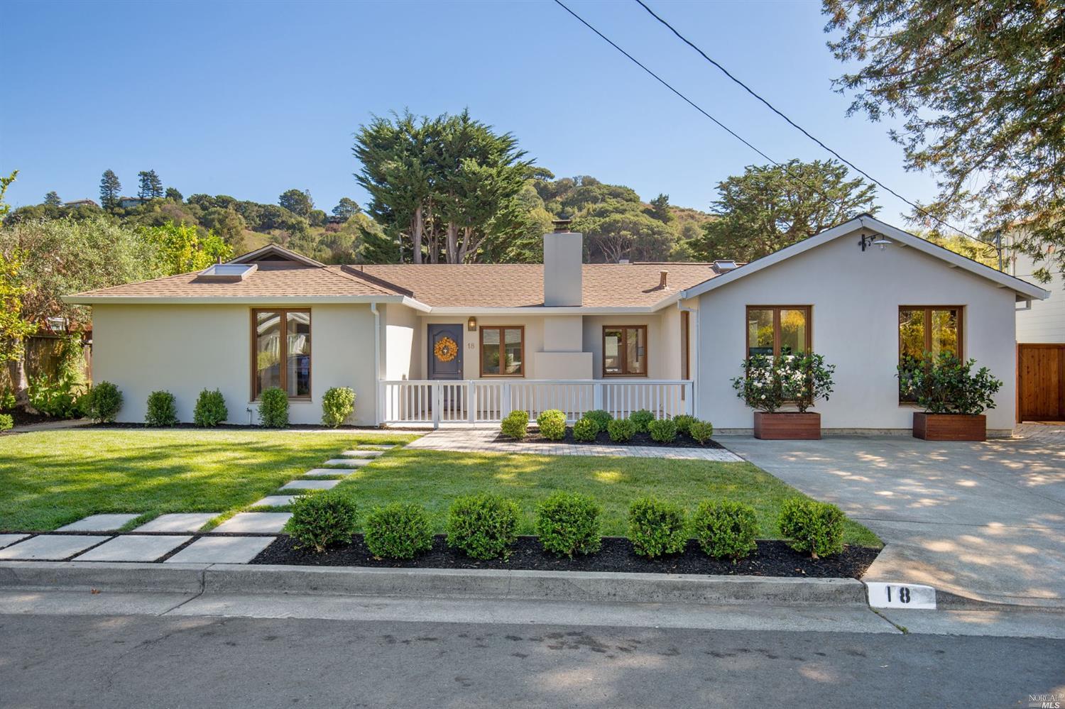 a view of a white house with a yard and plants