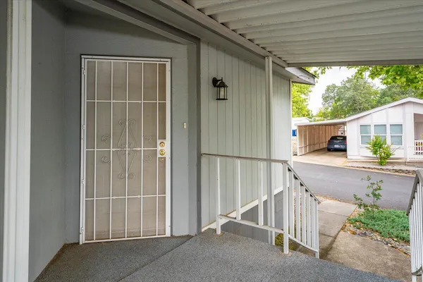 a view of a house with a yard and potted plants