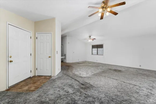 a view of a big room with chandelier fan and windows