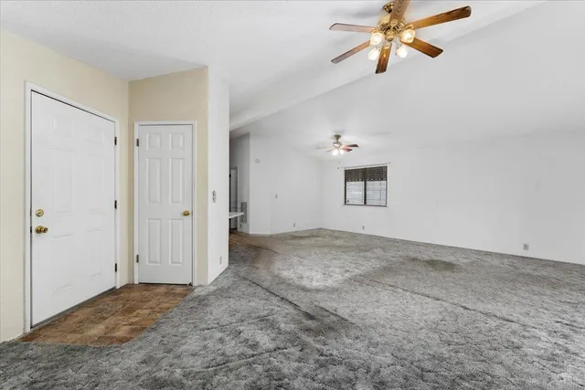 a view of a big room with chandelier fan and windows