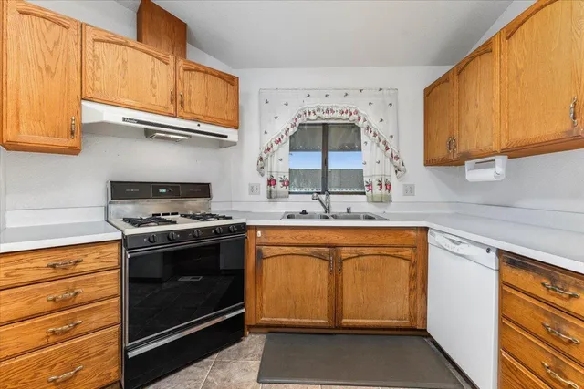 a kitchen with stainless steel appliances granite countertop a sink stove and cabinets