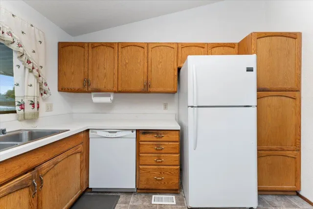 a kitchen with stainless steel appliances granite countertop a refrigerator and a sink