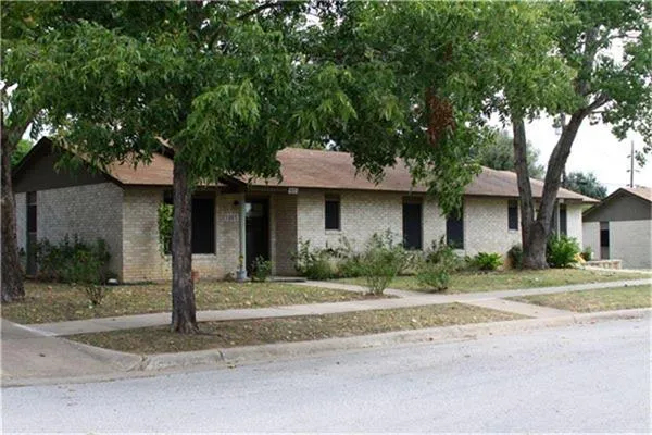 a front view of a house with a yard and potted plants