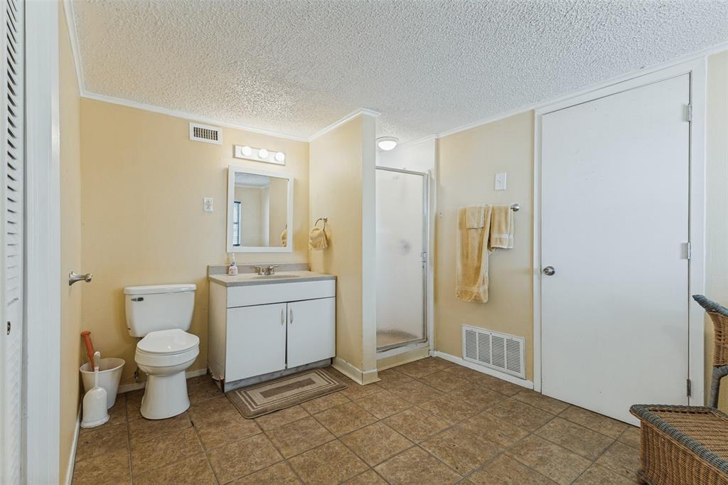 12960 Gantt Road East Azle, TX 76020 - Photo 14 of 26 Bathroom featuring a single vanity with a white cabinet, a white toilet, a mirrored medicine cabinet, a shower stall with a clear glass enclosure, and tiled flooring