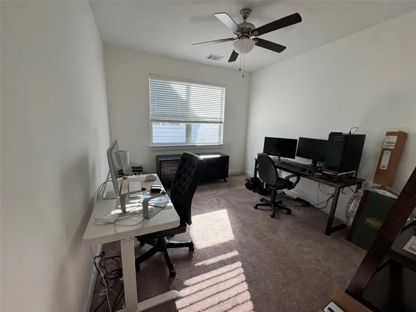 a view of a workspace with furniture and a window