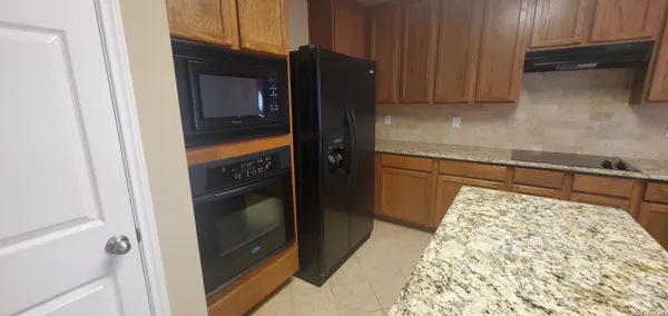a kitchen with a refrigerator and a stove