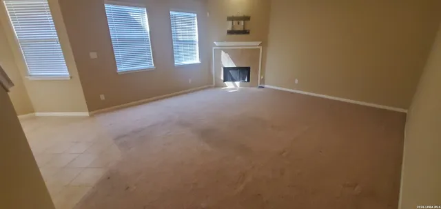 a view of an empty room with a fireplace and a window