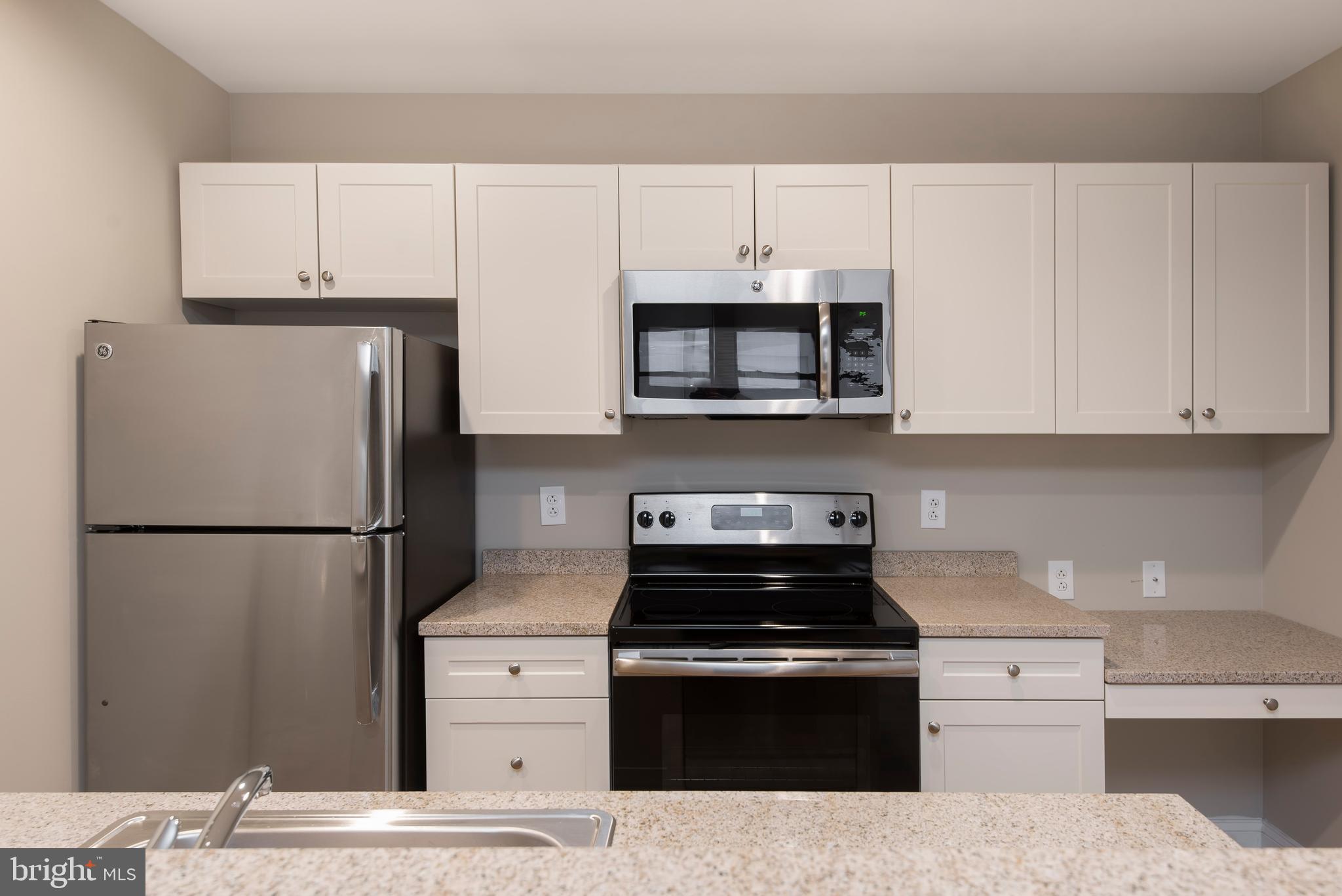 220 South 16th Street, Unit 902 Philadelphia, PA 19102 - Photo 8 of 16 a kitchen with stainless steel appliances a refrigerator stove and microwave