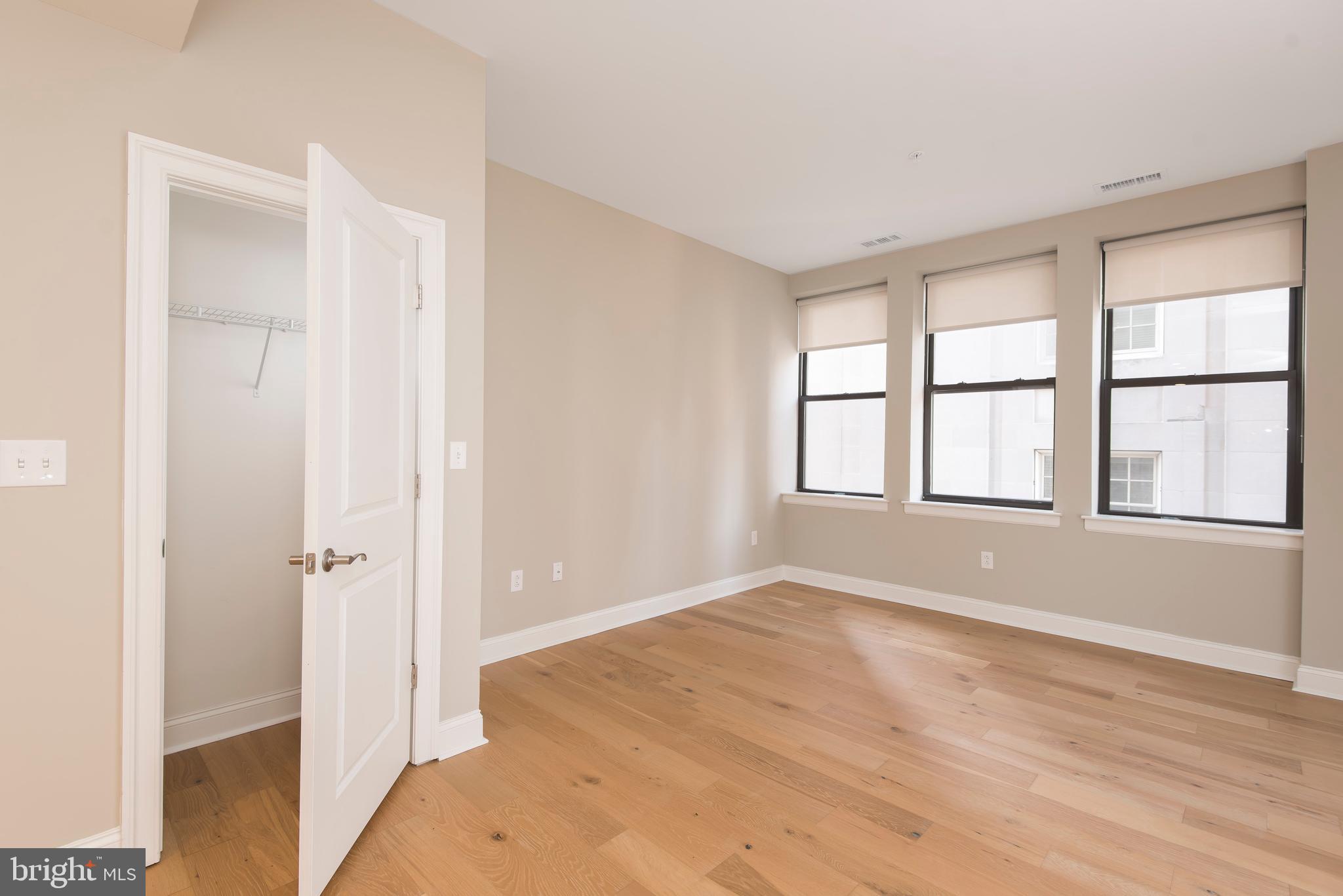 220 South 16th Street, Unit 902 Philadelphia, PA 19102 - Photo 9 of 16 a view of an empty room with wooden floor and a window