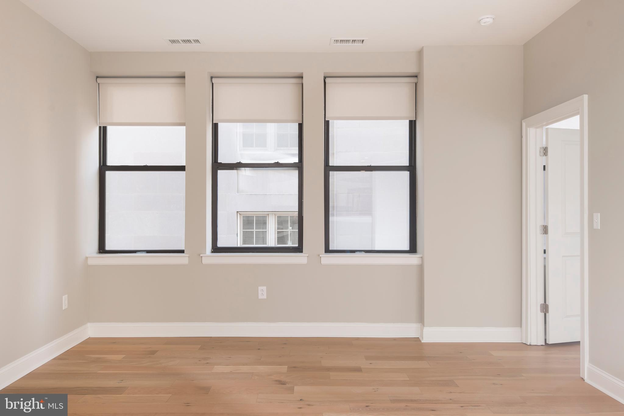 220 South 16th Street, Unit 902 Philadelphia, PA 19102 - Photo 10 of 16 an empty room with wooden floor and windows