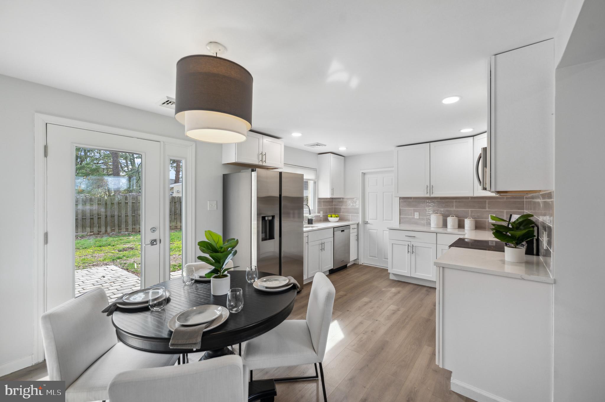 2210 Sproul Road Broomall, PA 19008 - Photo 1 of 26 a kitchen with a refrigerator and a dining table