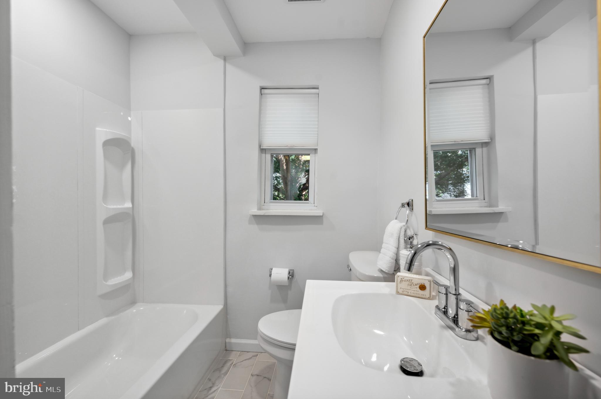 2210 Sproul Road Broomall, PA 19008 - Photo 22 of 26 a bathroom with a tub sink toilet and mirror