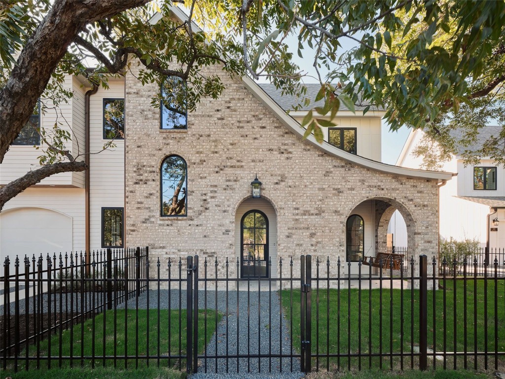 610 Allen Street, Unit 1 Austin, TX 78702 - Photo 1 of 32 View of front facade featuring a gate, brick siding, a fenced front yard, and a garage