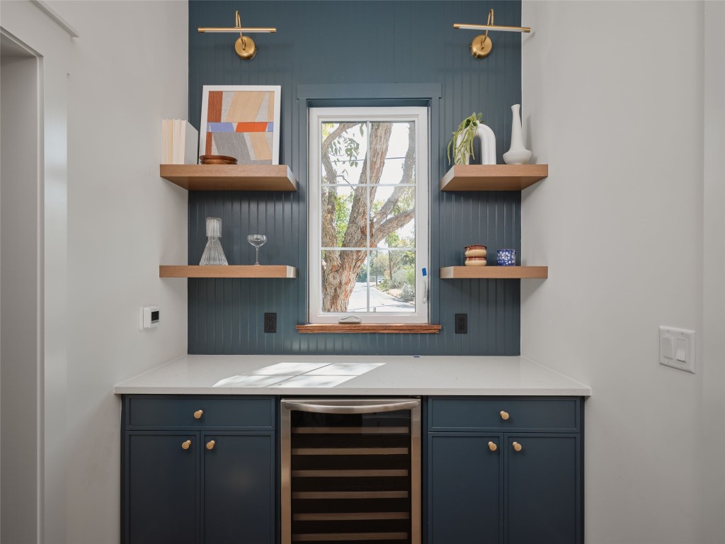 610 Allen Street, Unit 1 Austin, TX 78702 - Photo 14 of 32 Indoor dry bar featuring beverage cooler, blue cabinets, light stone countertops, and open shelves