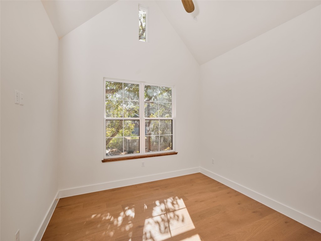 610 Allen Street, Unit 1 Austin, TX 78702 - Photo 22 of 32 Empty room with light wood finished floors, high vaulted ceiling, and a ceiling fan
