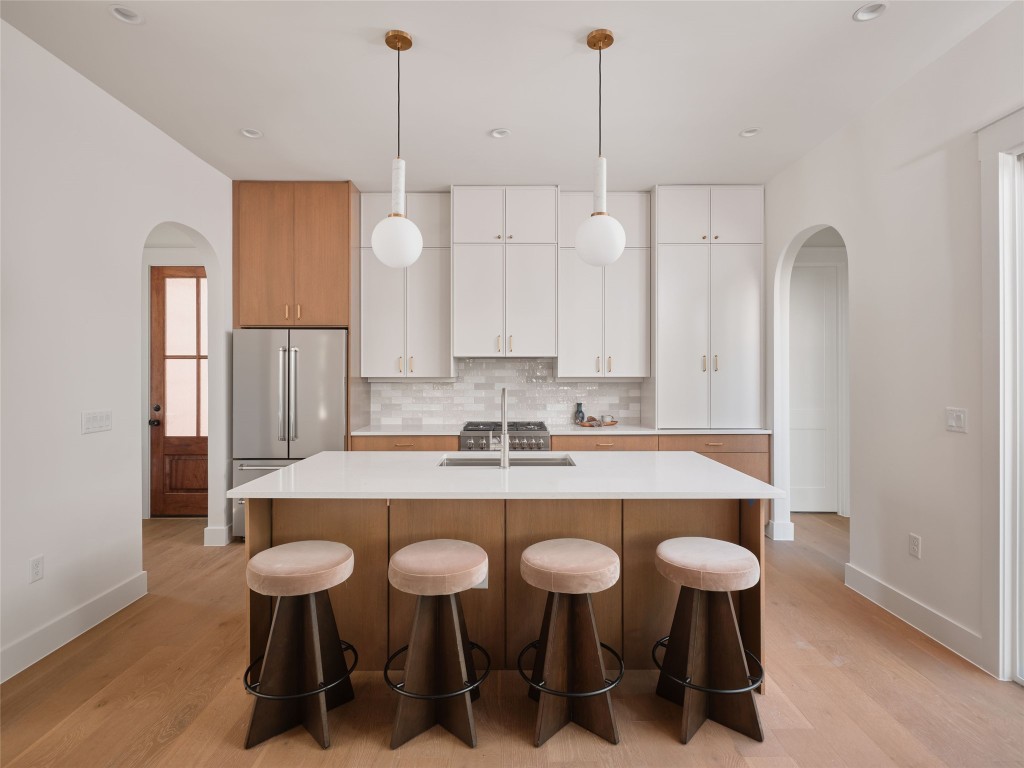 610 Allen Street, Unit 1 Austin, TX 78702 - Photo 5 of 32 Kitchen with arched walkways, white cabinetry, high end refrigerator, brown cabinets, and recessed lighting