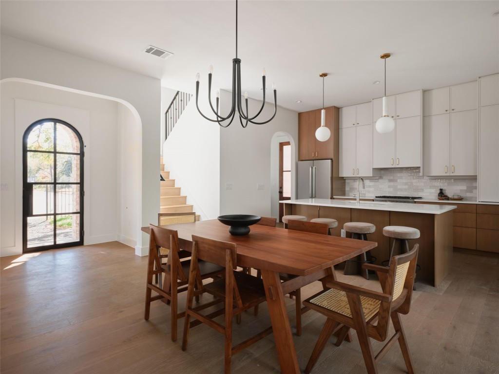 610 Allen Street, Unit 1 Austin, TX 78702 - Photo 7 of 32 Dining space featuring arched walkways, stairway, and light wood finished floors