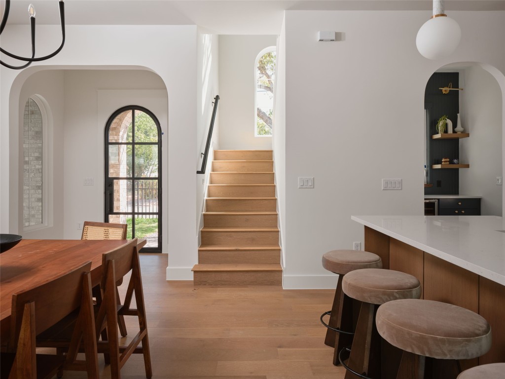 610 Allen Street, Unit 1 Austin, TX 78702 - Photo 10 of 32 Dining area with arched walkways, light wood-style flooring, and stairs