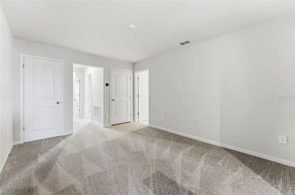 a bedroom with a bed and a flat tv screen on wall