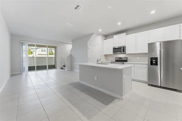 a kitchen with a sink a counter top space stainless steel appliances and cabinets