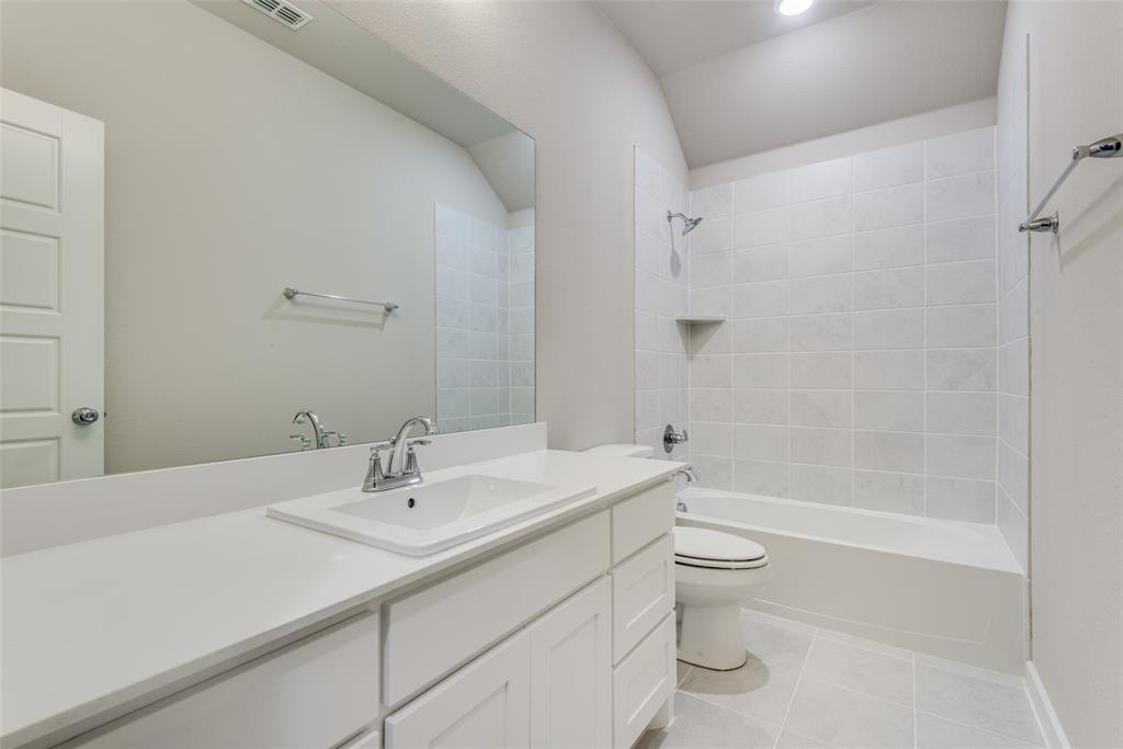 2544 Rambling Road Celina, TX 75009 - Photo 15 of 25 Full bathroom featuring tiled shower / bath combo, vanity, toilet, and tile floors