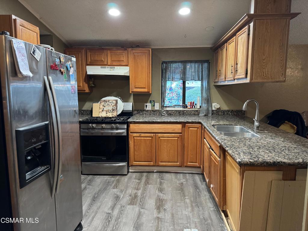 40701 Rancho Vista Boulevard, Unit 76 Palmdale, CA 93551 - Photo 9 of 31 a kitchen with stainless steel appliances granite countertop a sink stove and refrigerator