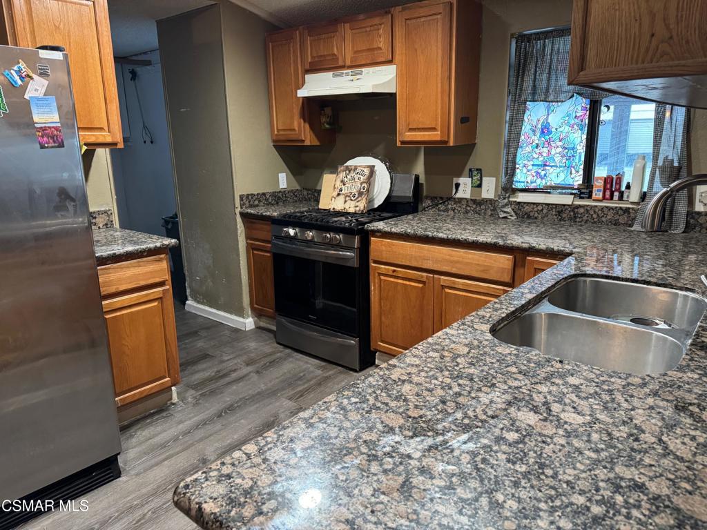 40701 Rancho Vista Boulevard, Unit 76 Palmdale, CA 93551 - Photo 10 of 31 a kitchen with granite countertop a sink stove and cabinets