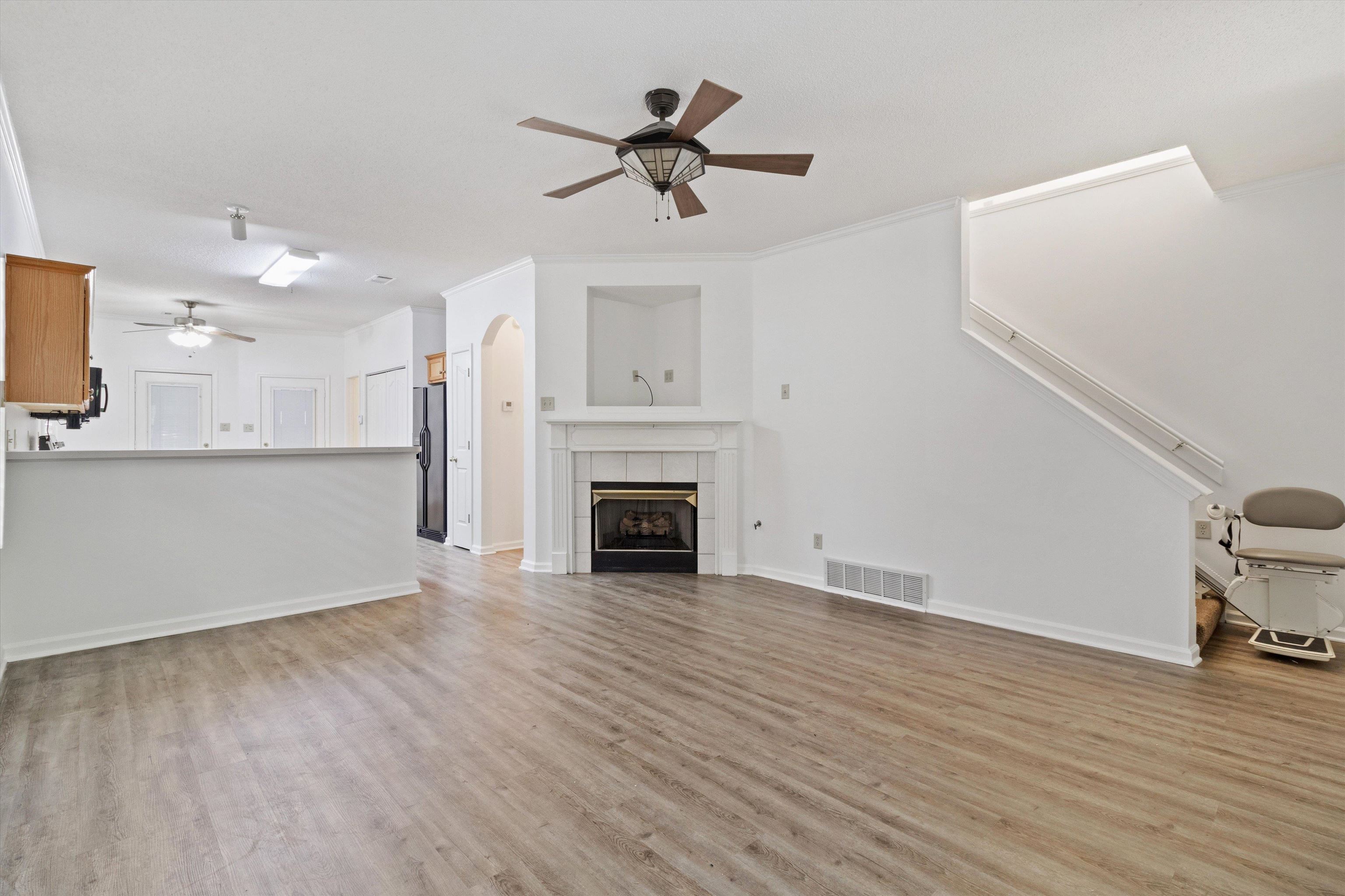 1262 South Collierville Arlington Road Collierville, TN 38017 - Photo 5 of 26 a view of a livingroom with a fireplace a ceiling fan and wooden floor