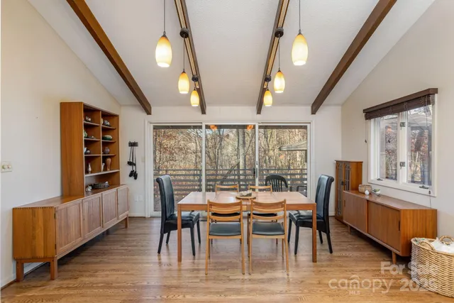 a dining room with furniture large windows and wooden floor