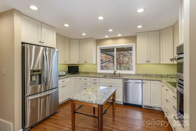 a kitchen with stainless steel appliances granite countertop a refrigerator and a stove top oven