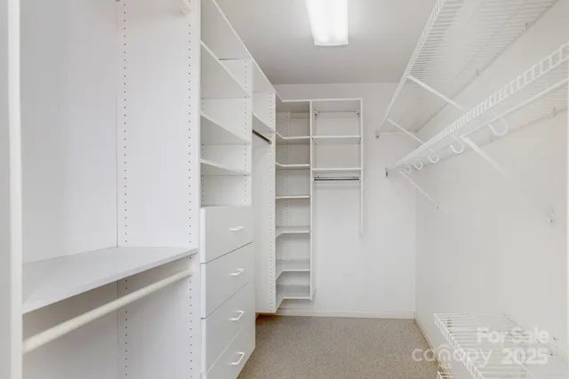 a view of walk in closet with empty racks