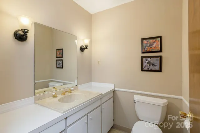 a bathroom with a sink mirror vanity and toilet