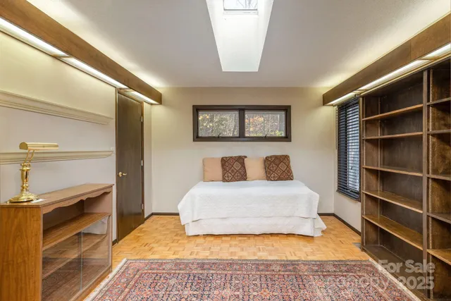 a spacious bedroom with a bed and a television