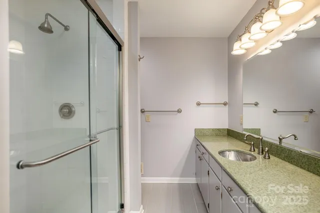 a bathroom with a granite countertop sink a shower and mirror
