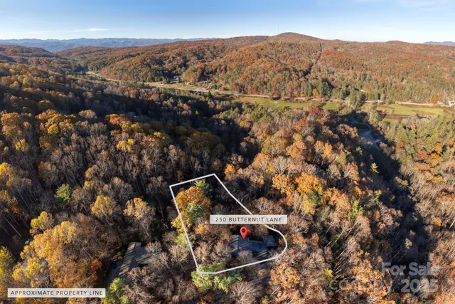 an aerial view of house with yard and mountain view in back