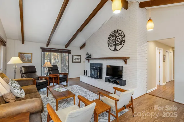 a living room with furniture a fireplace and a flat screen tv