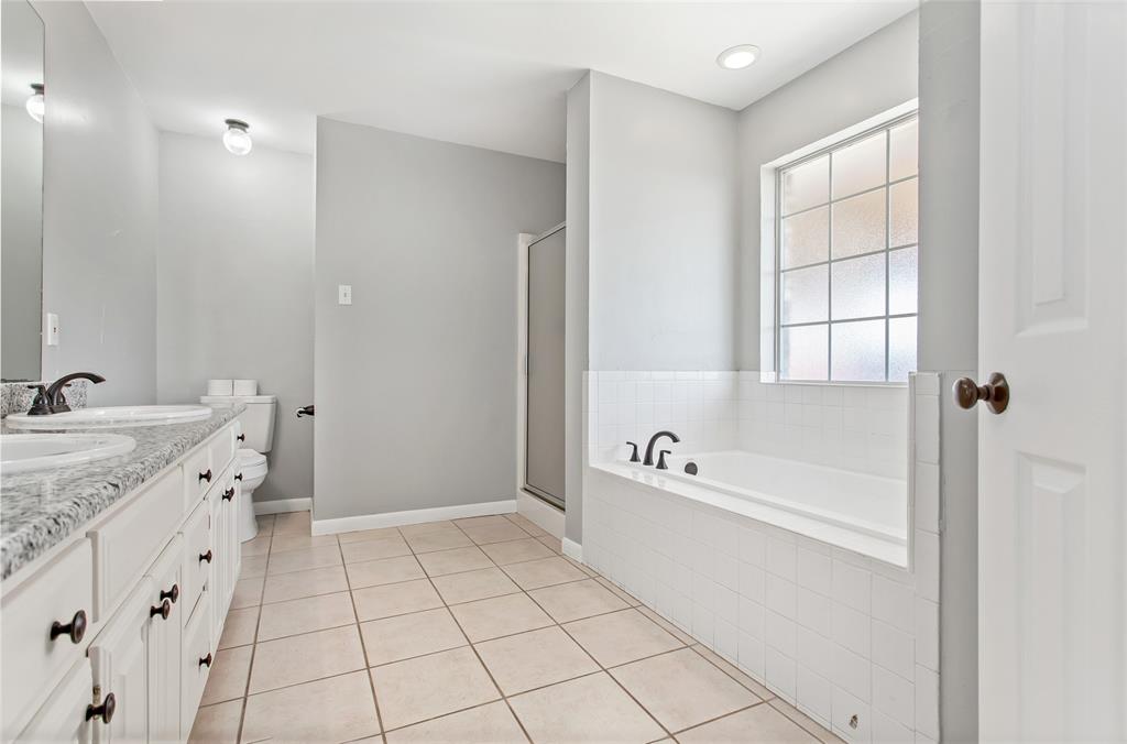 712 Billups Street Van Alstyne, TX 75495 - Photo 26 of 38 a spacious bathroom with a tub sink and mirror