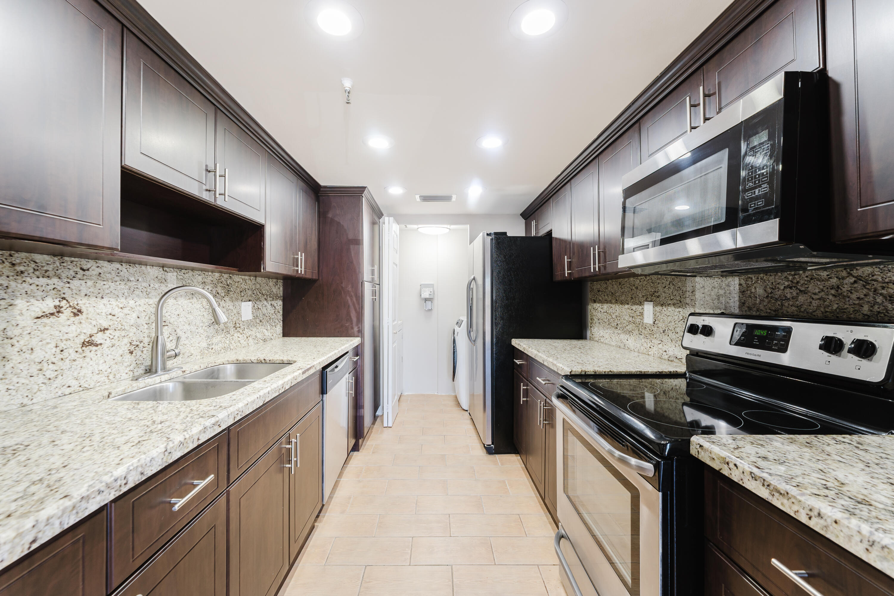859 Jeffery Street, Unit 208 Boca Raton, FL 33487 - Photo 18 of 39 a kitchen with stainless steel appliances granite countertop a sink and a stove