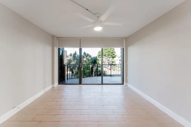 an empty room with a ceiling fan and window