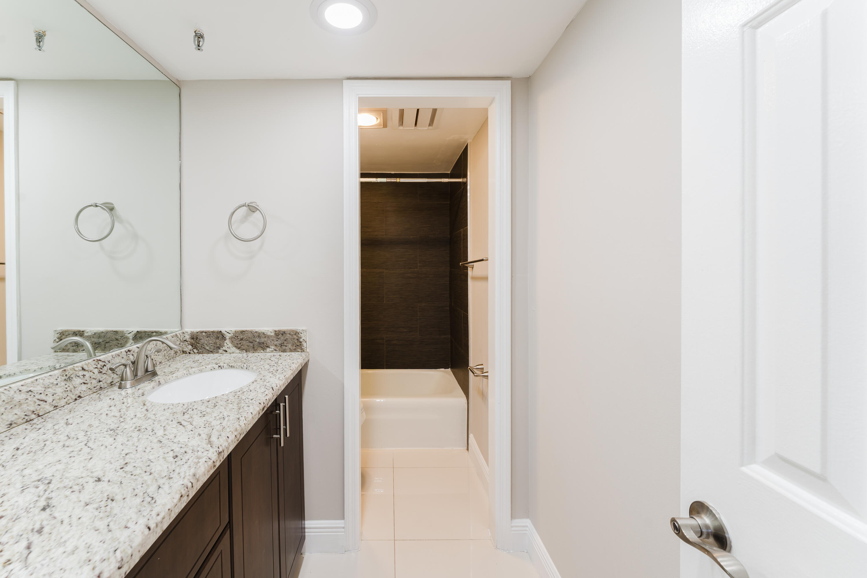 859 Jeffery Street, Unit 208 Boca Raton, FL 33487 - Photo 36 of 39 a bathroom with a granite countertop sink and mirror