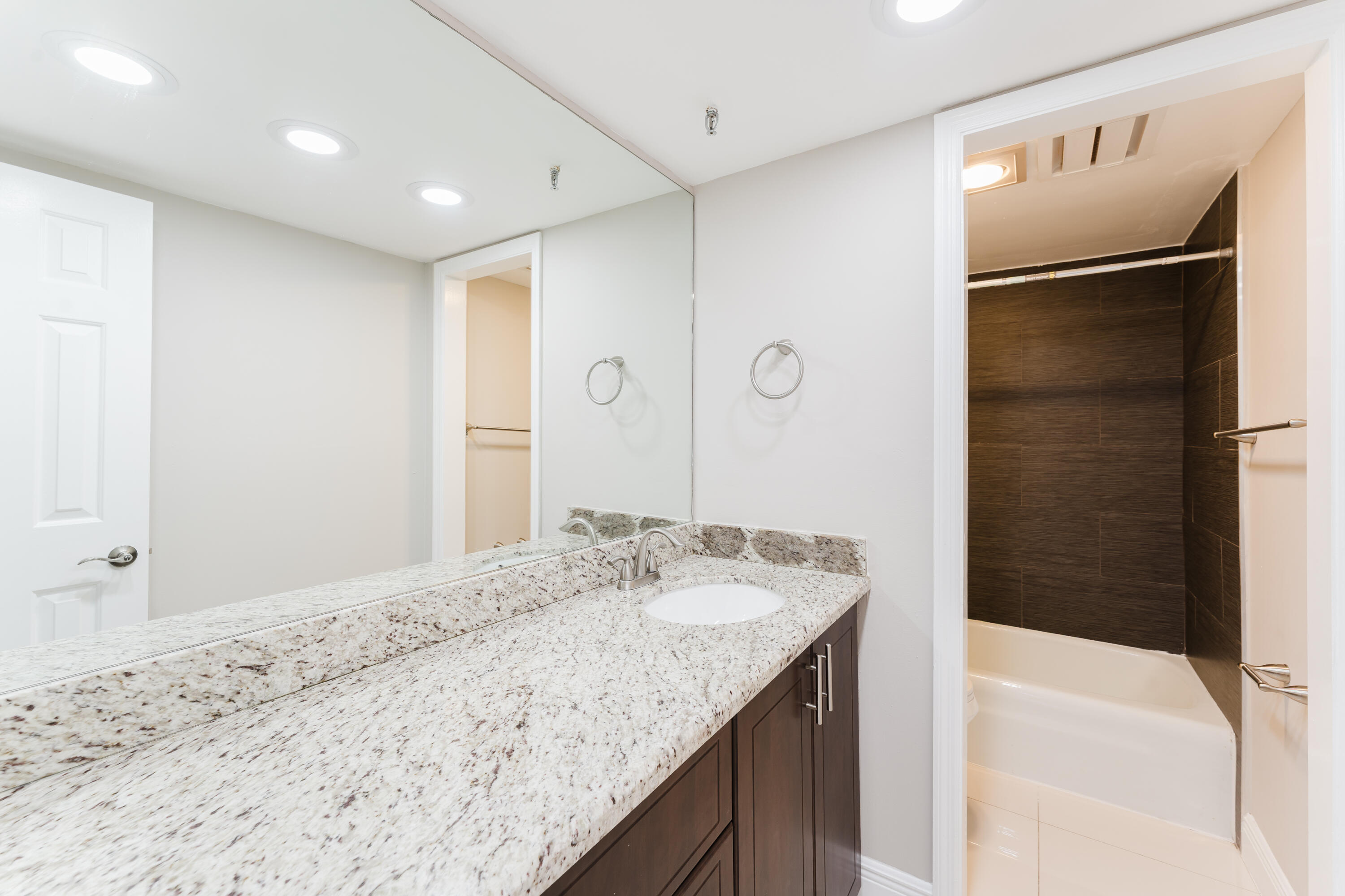 859 Jeffery Street, Unit 208 Boca Raton, FL 33487 - Photo 37 of 39 a bathroom with a granite countertop sink shower and a mirror